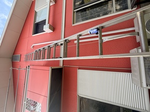 兵庫県神戸市垂水区の住宅で二連梯子を使用して換気口のコウモリ再侵入防止施工を行う様子